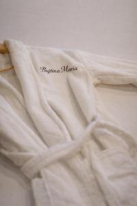 a white shirt with the words fijima marica on a bed at Bujtina Maria in Gjirokastër