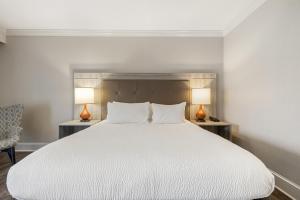 a bedroom with a large white bed with two lamps at The Ridges Resort on Lake Chatuge in Young Harris