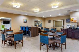a restaurant with tables and chairs and a bar at Springplace Inn & Suites in Marion