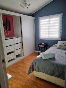 a bedroom with a bed and a dresser and a television at Los Camperos AR in Temuco