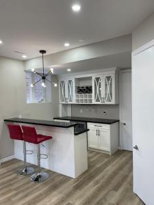 eine Küche mit einer Theke und einem roten Hocker in der Unterkunft New Basement Apartment unit sleeps 4 in Oakville