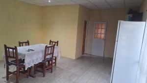 a dining room with a table and chairs and a refrigerator at Cande in Parana