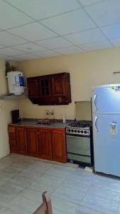a kitchen with a white refrigerator and wooden cabinets at Cande in Parana