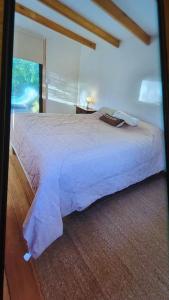 a large bed in a bedroom with a window at Piccolo Casa de playa La caleta in Mar de Cobo