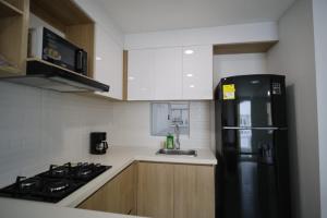a kitchen with a black refrigerator and a sink at Praseo in Serena del Mar +5 photos