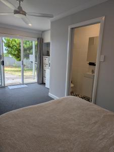 a bedroom with a bed and a door to a kitchen at The Elephants Nest in Victor Harbor
