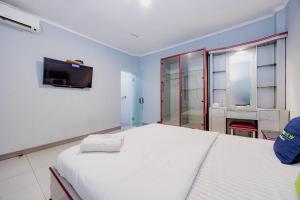 a bedroom with a bed and a tv on the wall at Urbanview Hotel Executive Residence Semarang by RedDoorz in Candi +25 photos