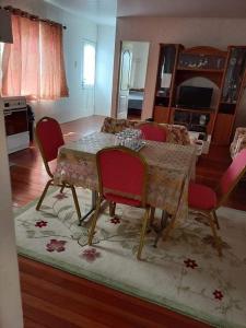 a dining room with a table with red chairs at Lotus Appartementen Nickerie in Majoor Fernandes