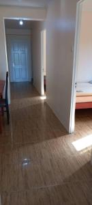 a room with a hallway with a bed and a wooden floor at Lotus Appartementen Nickerie in Majoor Fernandes