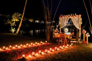 a group of people sitting at a table with candles at Cauayan Boutique Private Island - formerly Cauayan Island Resort in El Nido +136 photos