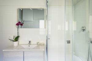 a white bathroom with a sink and a shower at Servi Apartment in Florence