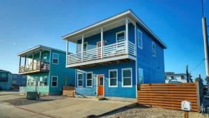 a blue house with a balcony on top of it at Ocean Devotion by AvantStay in Port Aransas