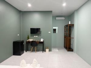 a room with a desk and a tv on a wall at Third Space House in Ban Nong Chaeng
