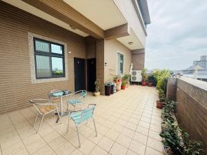 a patio with a table and chairs on a house at Frank B&B in Jincheng