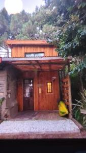 a small wooden house with a door in front of it at Piccolo Casa de playa La caleta in Mar de Cobo