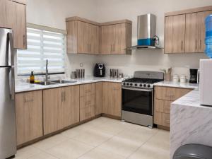a kitchen with wooden cabinets and a stove top oven at Casa Morada in Ciudad Juárez