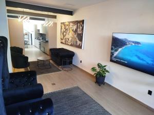 a living room with a flat screen tv on a wall at Día y noche in Guadalajara
