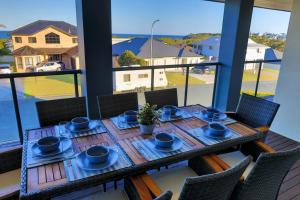 a table with blue dishes on it on a balcony at Diamond Beach Getaway - Diamond Beach in Diamond Beach
