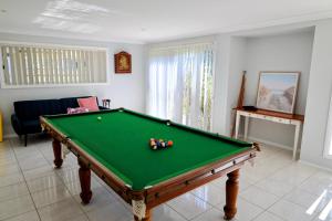 a living room with a pool table and a couch at Diamond Beach Getaway - Diamond Beach in Diamond Beach