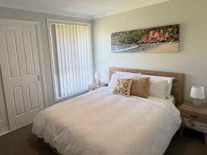 a bedroom with a bed and a large window at Diamond Beach Getaway - Diamond Beach in Diamond Beach