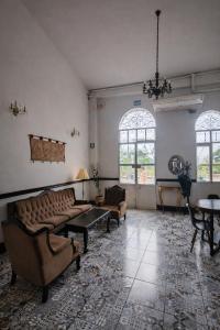 ein Wohnzimmer mit Sofas, Tischen und Fenstern in der Unterkunft Epoca Iquitos in Iquitos