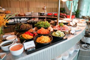 a buffet with bowls of food on a table at LiT BANGKOK Hotel in Bangkok