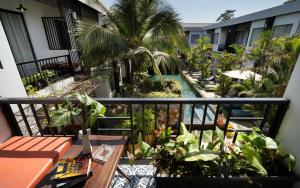 an apartment balcony with a pool and palm trees at Central Corner d'Angkor in Siem Reap