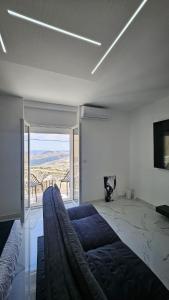 a living room with a bed and a large window at Modern Hillside Retreat with Panoramic Views in Mussomeli
