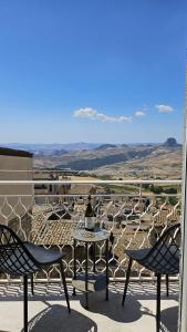 a table and chairs on a balcony with a view at Modern Hillside Retreat with Panoramic Views in Mussomeli
