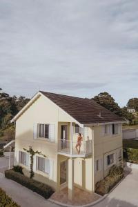 a house with a balcony and a man on the balcony at Motel Molly - Boutique Hotel Mollymook in Mollymook