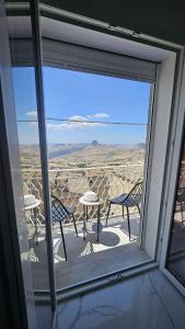 a view from a window of a patio with tables and chairs at Modern Hillside Retreat with Panoramic Views in Mussomeli