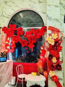 a room with red and yellow flowers and a table at A In Hotel Atistar in Ho Chi Minh City