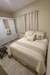a bedroom with a large bed and a mirror at Casa temporada Capuba in Serra