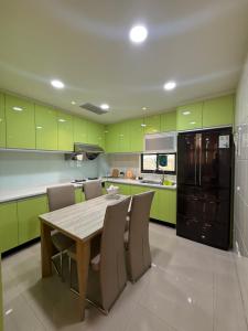 a kitchen with green cabinets and a wooden table and chairs at Frank B&B in Jincheng