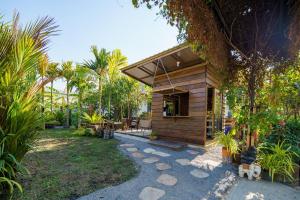 a small wooden house with a patio in a yard at เวลการ์เด้น101 in Ban Hua Phrong