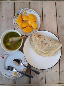 a table with plates of food and a bowl of soup at Hidalgo Explorers Home in Moshi