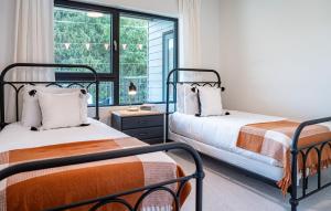 two beds in a room with a window at Tucker's Place in Revelstoke