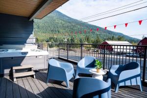 a balcony with chairs and a table with a view of a mountain at Tucker's Place in Revelstoke