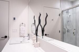 a white bathroom with a sink and a mirror at Tucker's Place in Revelstoke +62 photos