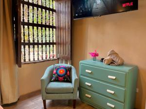 a bedroom with a dresser and a chair next to a drawer at Serenity Lodge in Ica