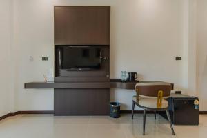 a kitchen with a table and a chair and a microwave at เวลการ์เด้น101 in Ban Hua Phrong