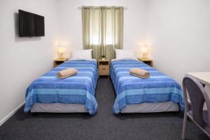 two beds in a room with blue and white blankets at Broken Hill Tourist Lodge in Broken Hill +44 photos