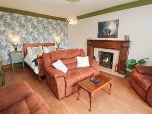 a living room with a couch and a fireplace at The Old Post Office in Matlock