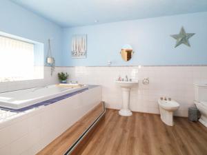 a bathroom with a tub and a toilet and a sink at The Old Post Office in Matlock +40 photos