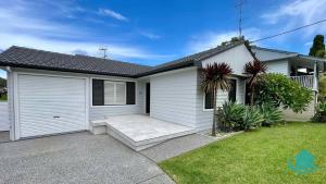 a white house with a garage at Casa Calvi - Central location with Pool in Jewells Station
