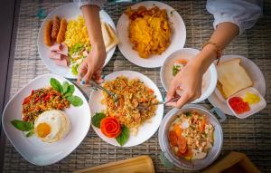 a table full of plates of food with people eating at Seree Grand Resort in Hat Yai
