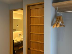a bathroom with a wooden closet with a sink at ミツカビルヂング in Kofu