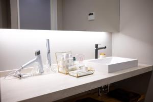 a bathroom counter with a white sink and a light at ミツカビルヂング in Kofu