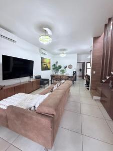 a living room with a long couch and a flat screen tv at Salvatierra Home in La Paz