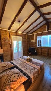 a bedroom with a large bed in a room with wooden walls at La Cachette in Le Marin